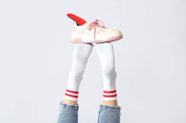 Kadın bacaklarında ortopedik tabanlı spor ayakkabılar beyaz arka planda izole edilmiş, yakın plan.