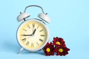 Mavi arka planda kasımpatı çiçekli çalar saat