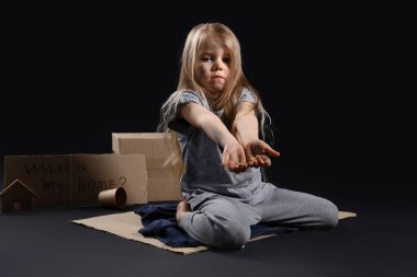 Evsiz küçük bir kız. Çöpten para dileniyor. Geçmişi karanlık.