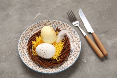 Paskalya yumurtaları ve gri arka planda tüy ile güzel bir masa.