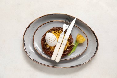 Paskalya yumurtası ve beyaz arka planda sarı lale ile güzel bir masa.