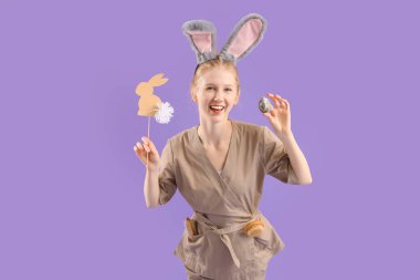 Mutlu kadın masaj terapisti fırçalar ve arka planda Paskalya dekoru.