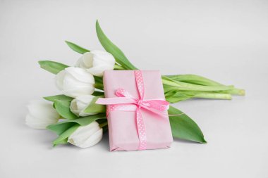 Beyaz arka planda lale çiçekleri olan hediye kutusu