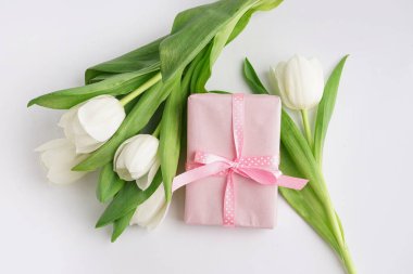 Beyaz arka planda lale çiçekleri olan hediye kutusu
