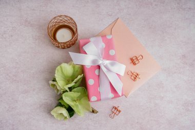 Güzel çiçekli hediye kutusu, beyaz arka planda zarf ve mum.