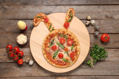 Tahta arka planda tavşan kulaklı Paskalya pizzası.