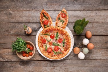 Tahta arka planda tavşan kulaklı Paskalya pizzası.