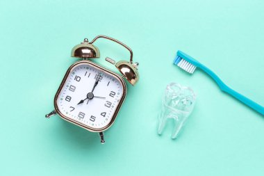 Çalar saat, plastik diş ve diş fırçası.