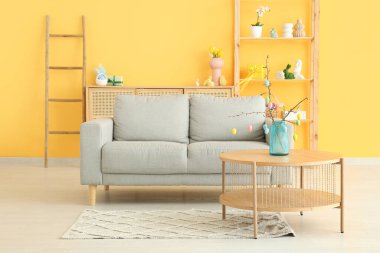 Paskalya kutlaması için dekore edilmiş şık oturma odasındaki kanepe ve masa.