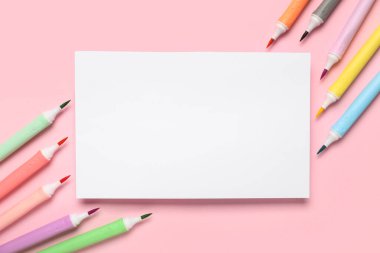 Pembe arka planda keçeli kalemleri olan bir kağıt. Okul bitti. Üst görünüm