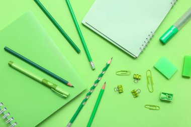 Yeşil arka planda farklı bir kırtasiye malzemesi. Üst görünüm