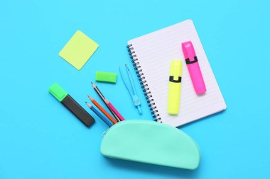 Mavi arka planda kırtasiye malzemesi olan kalem kutusu. Üst görünüm