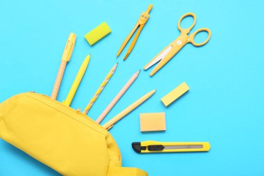 Mavi arka planda kırtasiye malzemesi olan kalem kutusu. Üst görünüm