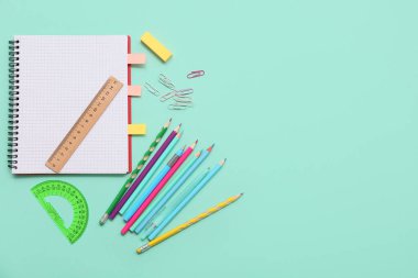 Turkuaz arka planda cetvel ve açıölçer olan defter. Üst görünüm