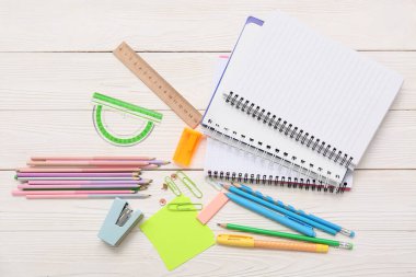 Beyaz ahşap arka planda farklı bir kırtasiye malzemesi. Üst görünüm