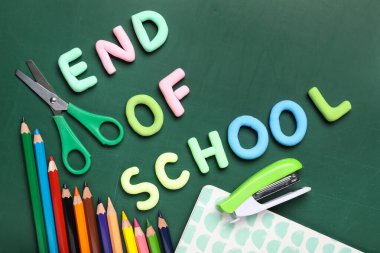 Okulun Metin Sonu, yeşil arkaplandaki kalem ve makas. Üst görünüm