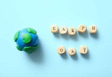 Dünya 'nın modeli ve renkli arkaplanda Dünya Günü yazılı tahta küpler. Dünya günü kutlaması.