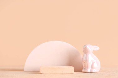 Bej arka planda oyuncak tavşanlı dekoratif podyumlar. Paskalya kutlaması