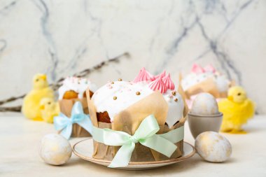 Beyaz arka planda yumurta ve piliçler olan lezzetli Paskalya pastaları.