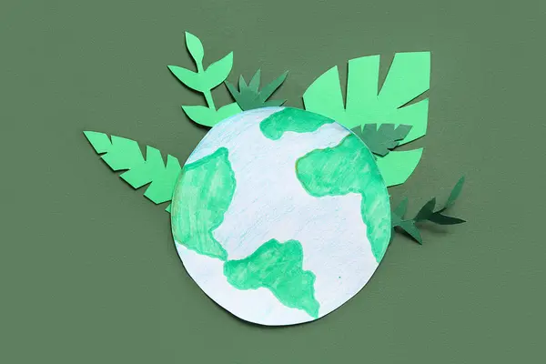 Paper planet Earth with green felt leaves on green background. Earth Day celebration.