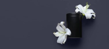 Mortuary urn and white lily flowers on black background with space for text. Funeral concept clipart