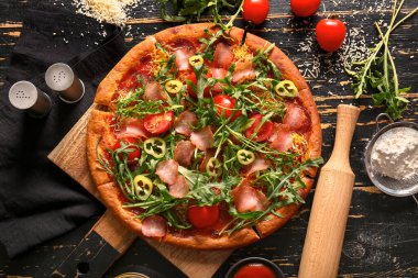 Siyah ahşap arka planda domatesli ve roka aromalı lezzetli pizzalar.