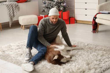 Evde sevimli köpekli yakışıklı bir genç adam.