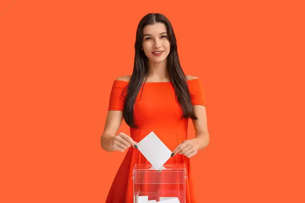 Junge Wahlhelferin Der Nähe Der Wahlurne Auf Orangefarbenem Hintergrund — Stockfoto