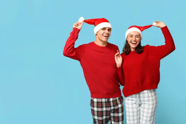 Feliz Jovem Casal Pijama Natal Chapéus Papai Noel Contra Fundo — Fotografia de Stock
