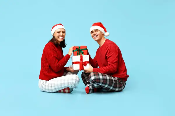 Jovem Casal Feliz Pijama Natal Com Presentes Sentados Contra Fundo — Fotografia de Stock