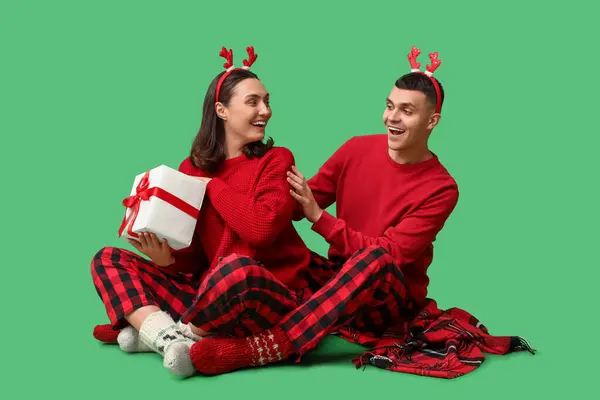 Glückliches Junges Paar Weihnachtlichen Pyjama Und Mit Geschenk Auf Grünem — Stockfoto