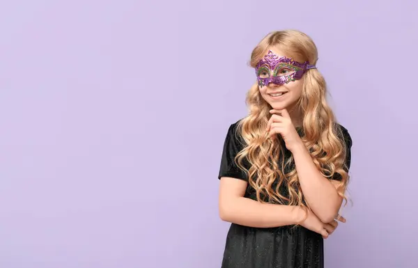 在紫丁香背景上戴着狂欢节面具的可爱小女孩 — 图库照片