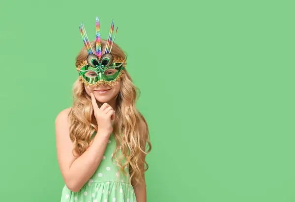 头脑清醒的小女孩戴着绿色背景的狂欢节面具 — 图库照片
