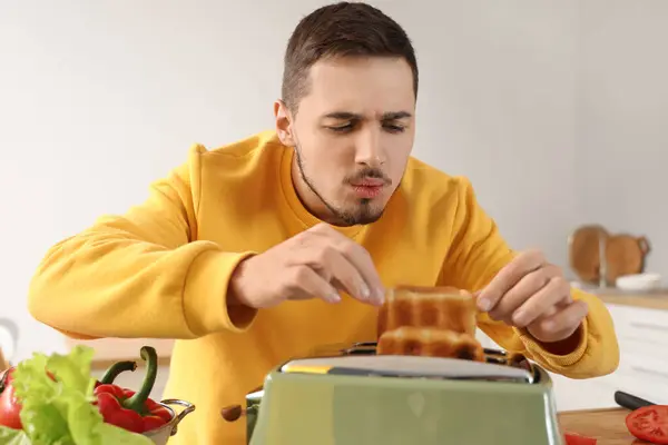 Молодий Чоловік Бере Гарячі Тости Тостера Кухні — стокове фото