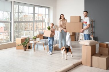 Karton kutuları ve taşınma gününde odada Beagle köpeği olan mutlu bir aile.