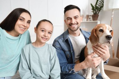 Taşındığı gün yatak odasında köpeği olan mutlu bir aile.