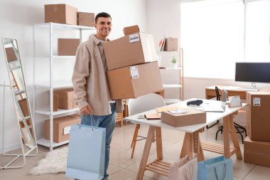 Depoda paket kutusu olan bir erkek çevrimiçi mağaza satıcısı.