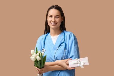 Beyaz laleli bayan doktor ve bej arka planda hediye kutusu. Kadınlar Günü kutlaması