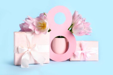 Hediye kutuları ve mavi arka planda güzel pembe laleleri olan kağıttan yapılmış 8 figür. Uluslararası Kadınlar Günü