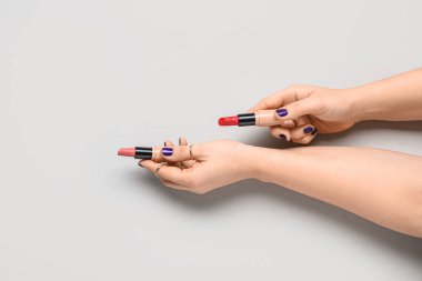 Gri arkaplanda ruj izi olan kadın elleri.