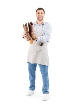 Beyaz arka planda çizmeleri olan erkek ayakkabıcı.