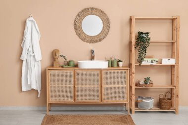 Banyoda kahverengi duvarın yanındaki tezgahta banyo malzemeleri olan modern lavabo.