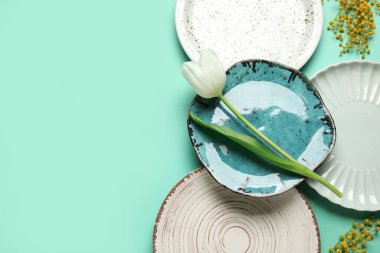 Beyaz lale ve turkuaz arka planda mimoza çiçekleri olan güzel bir masa.