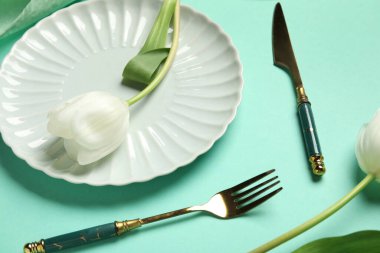 Turkuaz zemin üzerinde beyaz laleler olan güzel masa ayarları