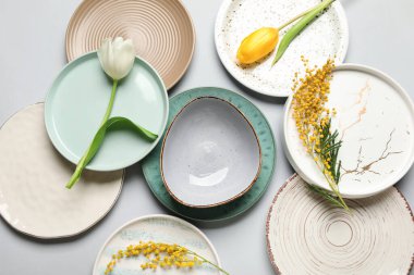 Gri arkaplanda güzel laleler ve mimoza çiçekleri olan masa ayarı