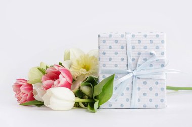 Beyaz arkaplanda farklı çiçekler olan hediye kutusu