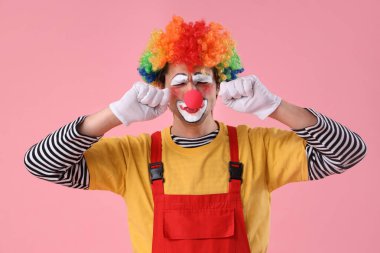 Pembe arka planda üzgün palyaço portresi. 1 Nisan şakası