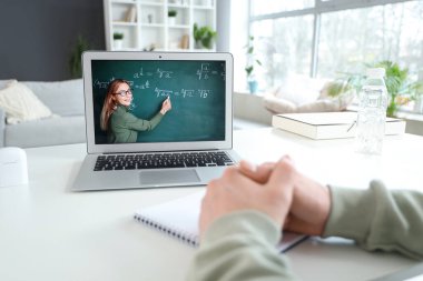 Erkek öğrenci evde online matematik okuyor, yakın plan.