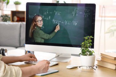 Erkek öğrenci evde internet öğretmeniyle Matematik okuyor, yakın plan.