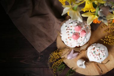 Tahta tepside Paskalya pastaları, tavşanlar, narsisler ve mimoza.